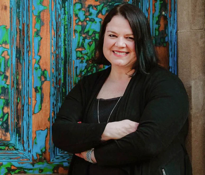Woman smiling, leaning with crossed arms for real menopause stories