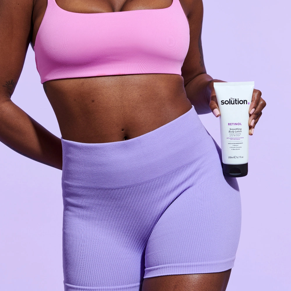 Model holding The Solution Retinol Smoothing Body Lotion
