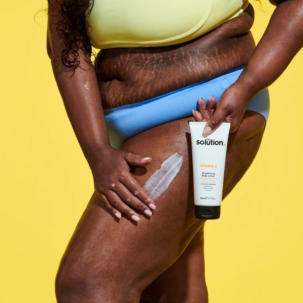 Model holding The Solution Vitamin C Brightening Body Lotion
