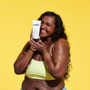 Model holding The Solution Vitamin C Brightening Body Lotion